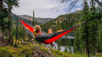 How to relax on Mother's Day: a woman reclines in a hammock strung between two trees