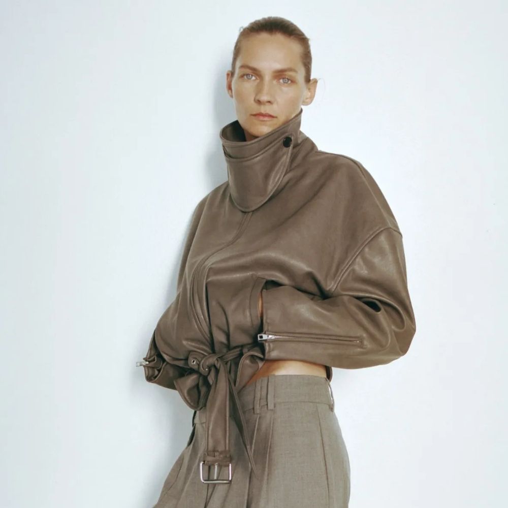 Woman wears leather-look jacket and tailored trousers