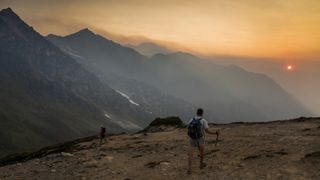 Two hikers on Glacier Peak in wildfire smoke haze