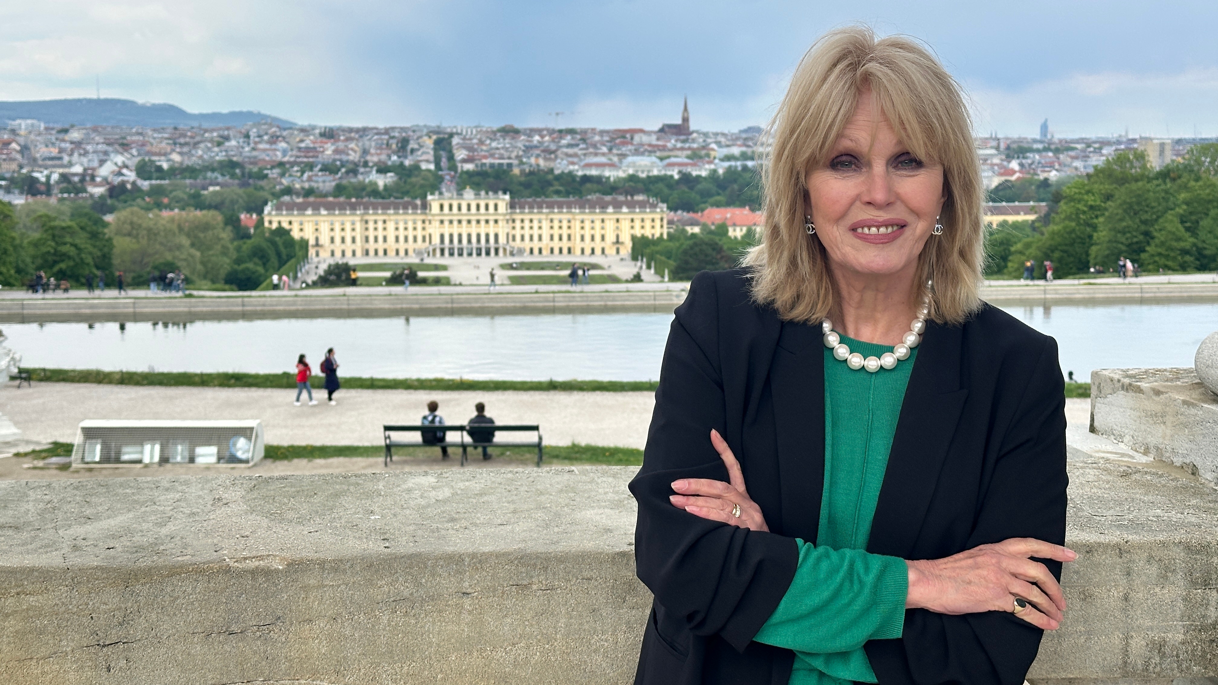 Joanna in a green top, dark cardigan and pearls with the river behind her in the background