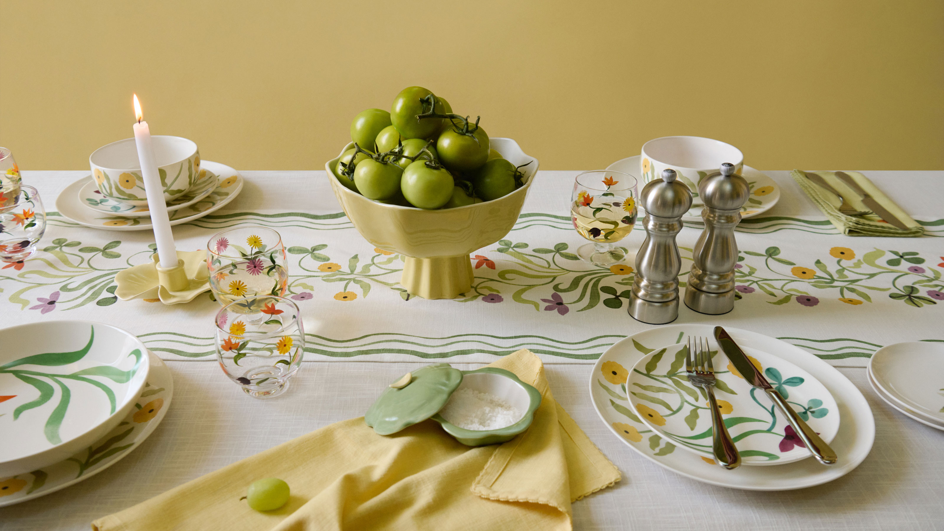 John Lewis Anine Cecile Iverson collection of yellow and floral tableware on a white tablecloth with a green floral design