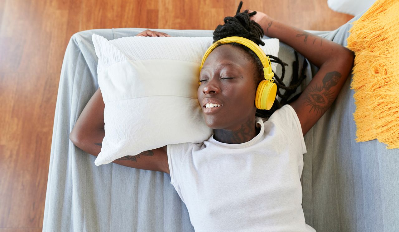 Woman asleep listening to ASMR through headphones