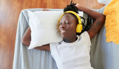 Woman asleep listening to ASMR through headphones