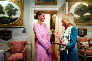 Camilla, Duchess of Cornwall talks with Zara McDermott at reception at Clarence House in London to mark 50 years of Refuge