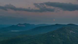 The Blue Moon of 2015 is seen setting over Table Rock Mountain in South Carolina in this stunning view by photographer on July 31, 2015 during the second full moon of the month.