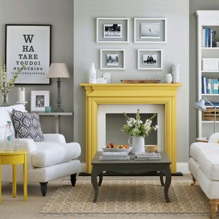 a Victorian grey living room with a yellow mantel and white sofas