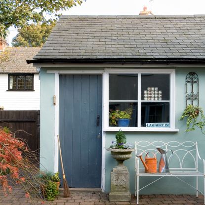 White window frame with blue wall and brick roof