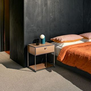 beige steel frame side table next to bed