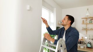 A picture of a man installing smart home items