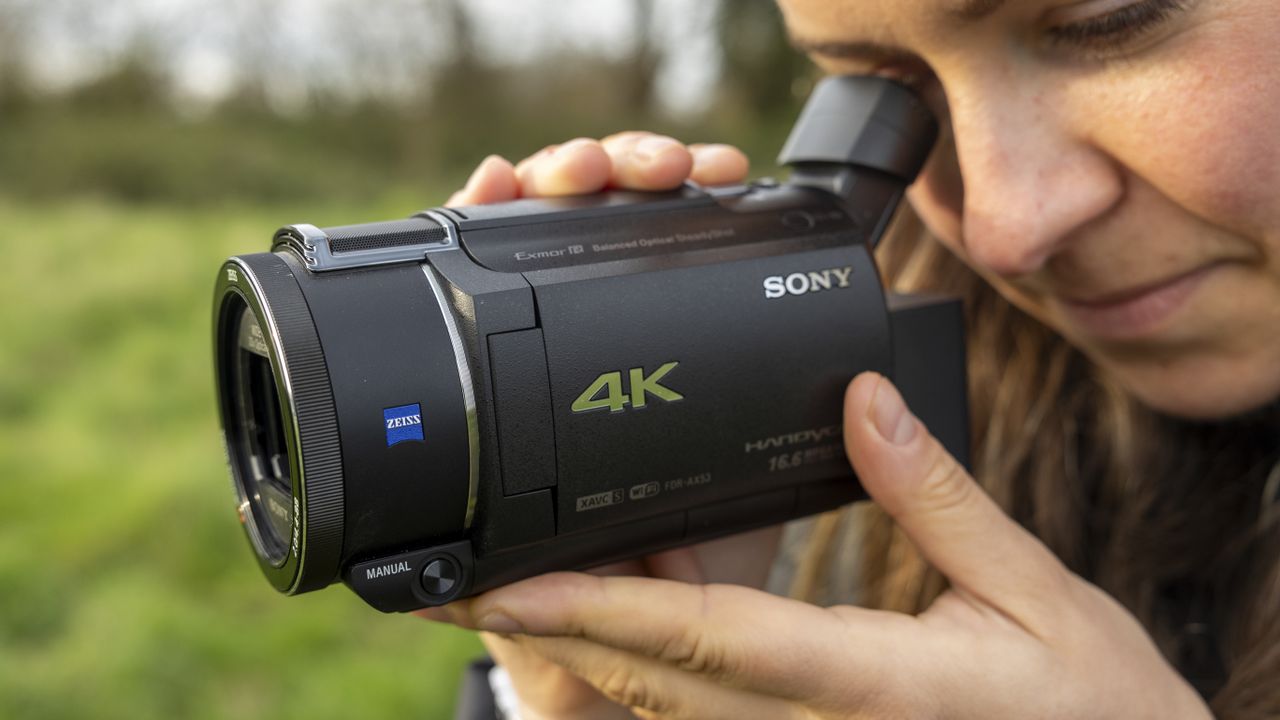 A close-up of a female photographer looking into the Sony FDR-AX53 viewfinder