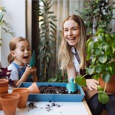 Woman and child laughing holding plants