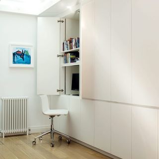 bed room with white cabinet white wall and white chair