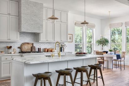 a white kitchen with tiled cooker hood and backsplash
