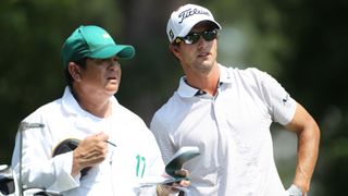 Adam Scott of Australia chats with his caddie Tony Navarro on the fourth hole during the final round of the 2011 Masters Tournament on April 10, 2011 in Augusta, Georgia.