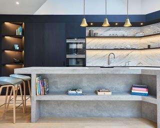 Modern kitchen with blue walls, marble backsplash, pendants and concrete island
