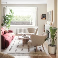 Netural living room with boucle armchairs, marble coffee table, and red sofa