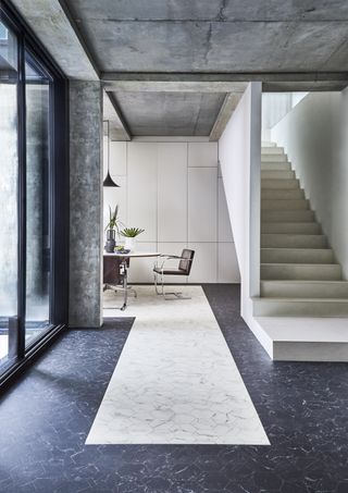 modern entryway with luxury vinyl stone effect flooring, dining table in background, stone staircase