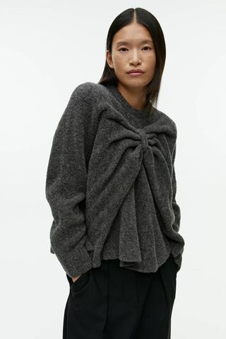 arket sale - woman wearing grey jumper with draped bow detail