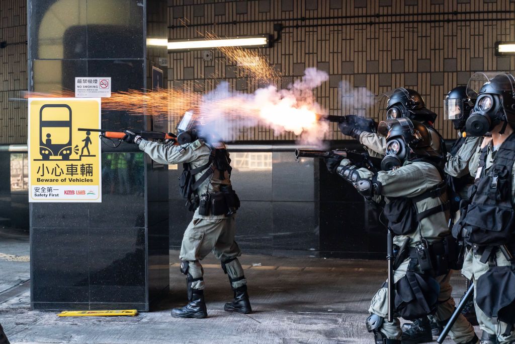 Riot police in Hong Kong fire tear gas canisters at protesters.