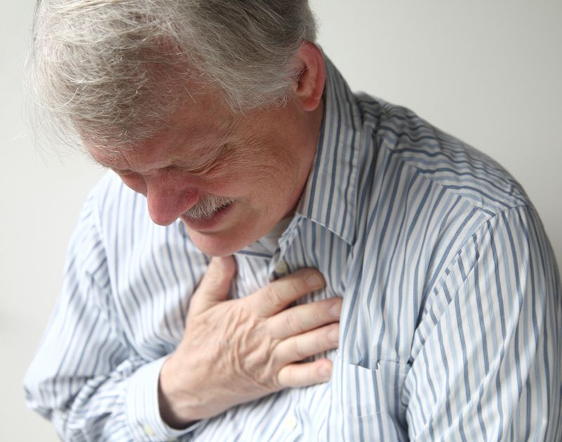 A man grips his chest in pain