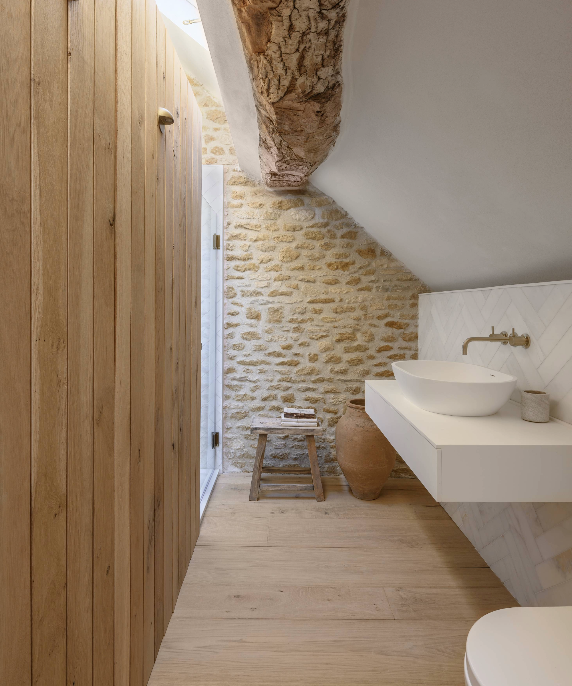 Toilet with basin and exposed brick wall 
