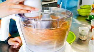 Food processor in the process of chopping cookies into a fine crumb