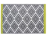 A geometric patterned black and white outdoor rug with lime green edges
