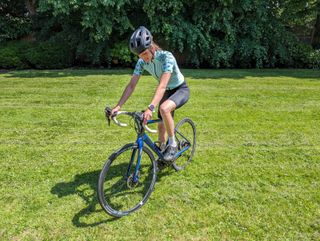 Ellie practicing using her clipless shoes on grass