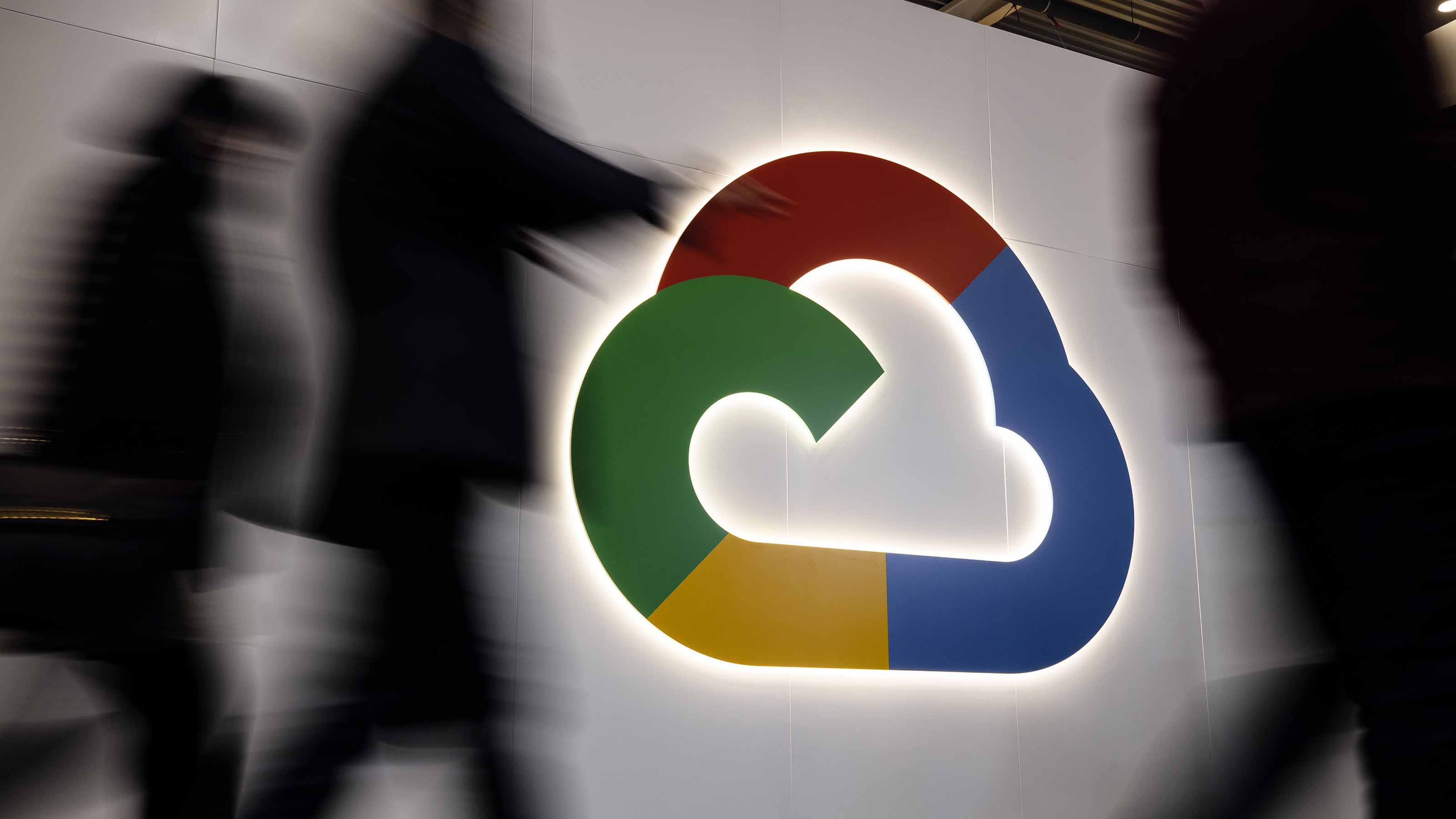 people walking in front of big Google Cloud logo on wall