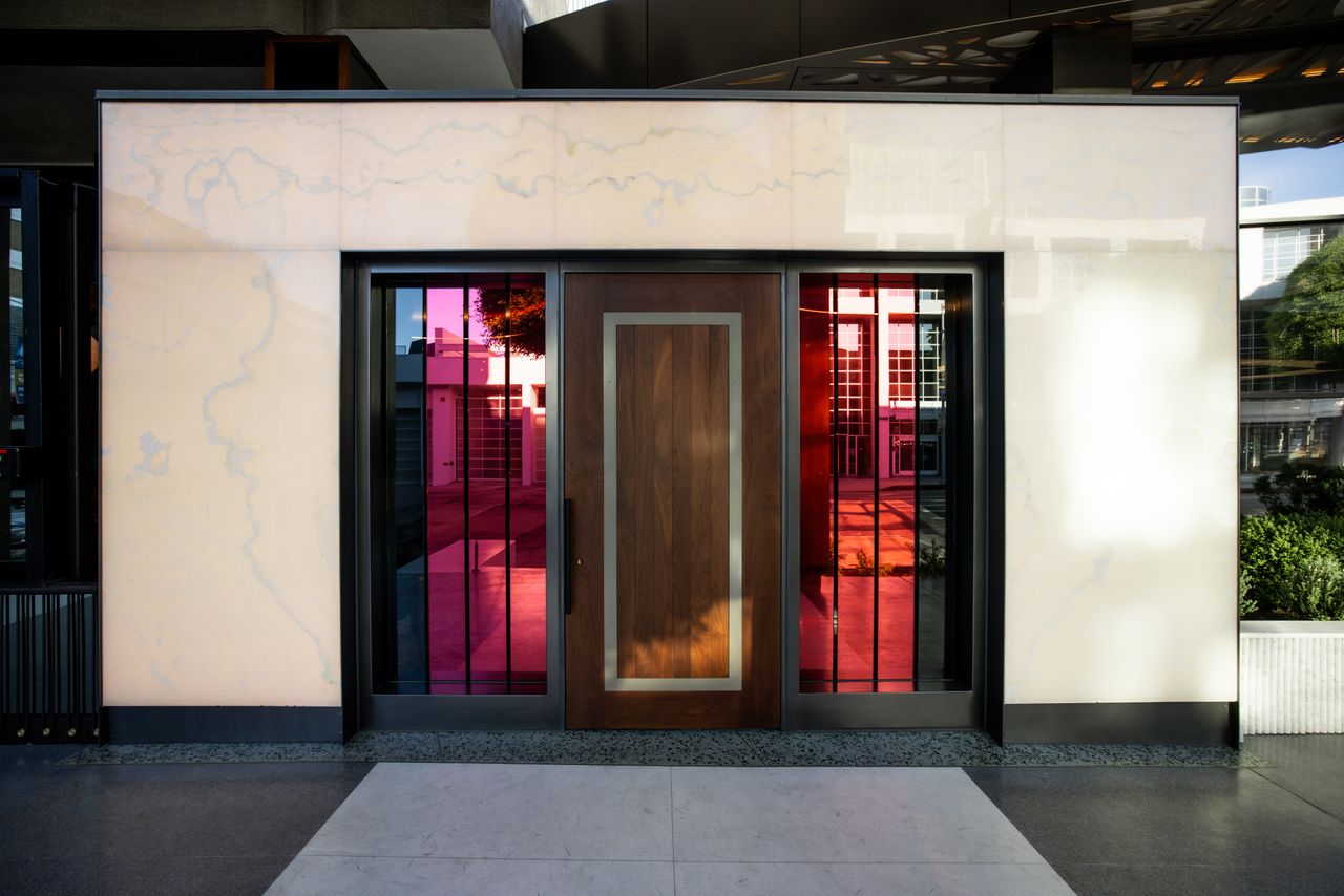 A stained glass window-adorned front entrance features a heavy wooden door and a marble frame.