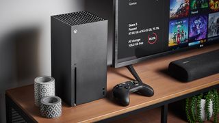 Xbox Series X review; a black Xbox games console on a table with a TV
