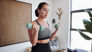 Woman performing dumbbell biceps curl at home