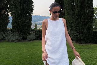 Woman standing outside wearing a white dress outfit.