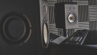 A pair of studio monitors on stands in a recording studio