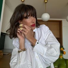 French woman Julie Sergent Ferreri wearing white shirt with bright red lipstick as an autumn beauty trend.