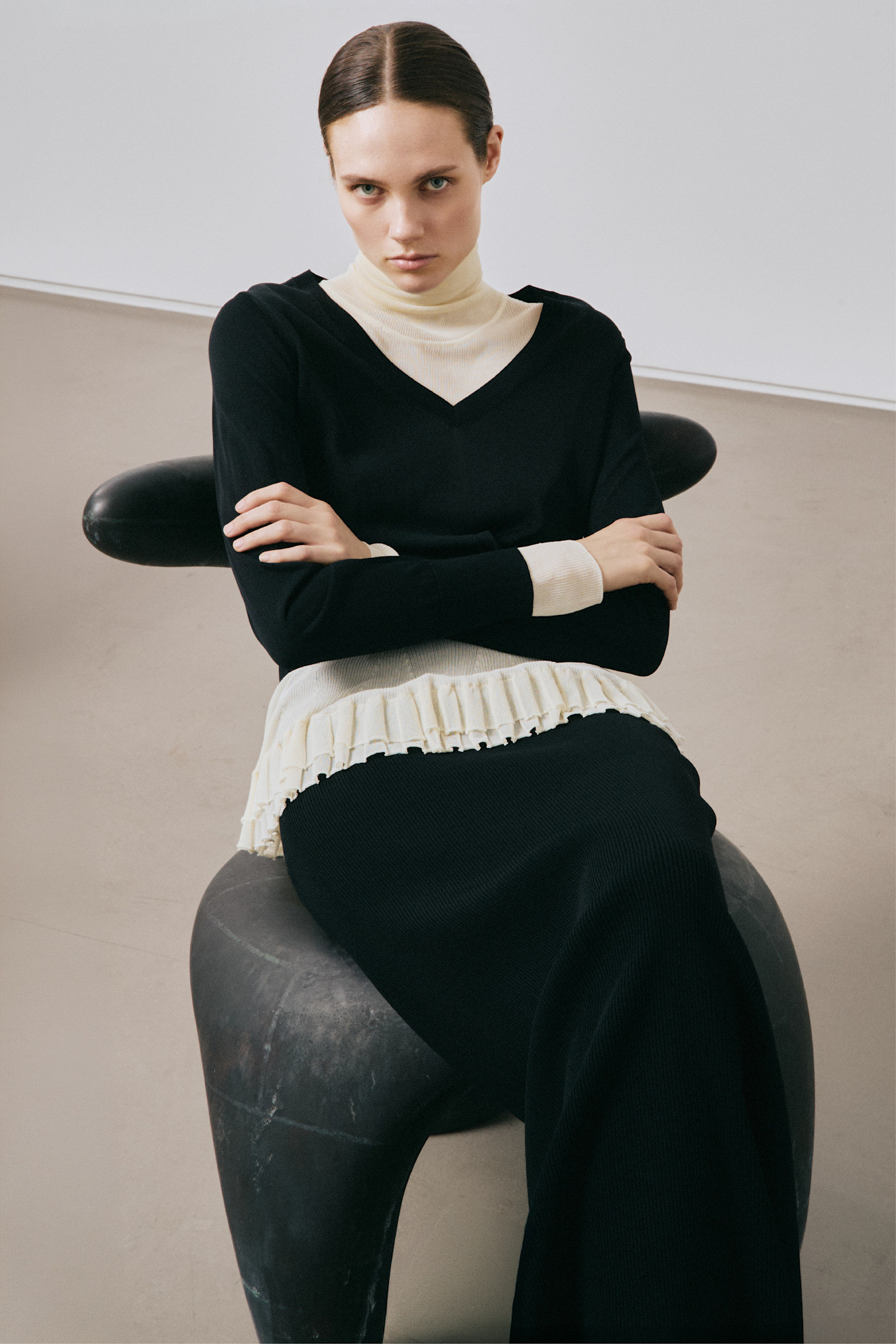 an Ashlyn brand model sitting in a chair with her arms folded