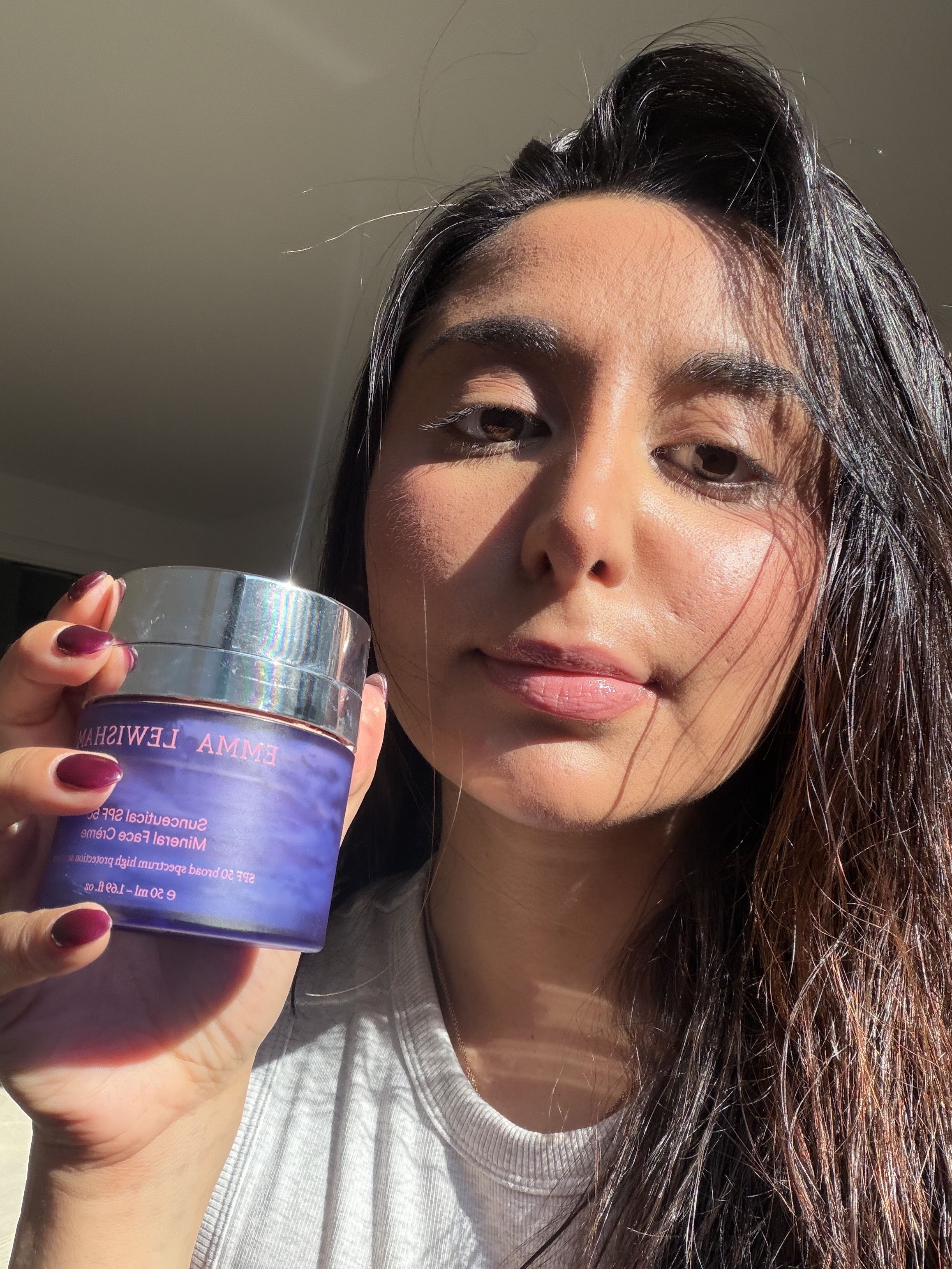 Senior Shopping Editor Marina testing and holding up the Emma Lewisham SPF.
