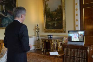 Queen Elizabeth II appears on a screen via videolink from Windsor Castle, where she is in residence, during a virtual audience to receive the as Ambassador from the Swiss Confederation, Markus Leitner at Buckingham Palace, on October 26, 2021 in London, England.