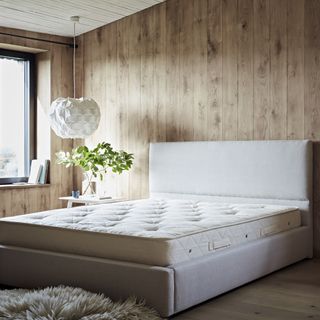 Bedroom with wooden walls and bare mattress