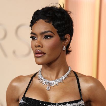 a black woman with short, dark hair poses on the oscars red carpet