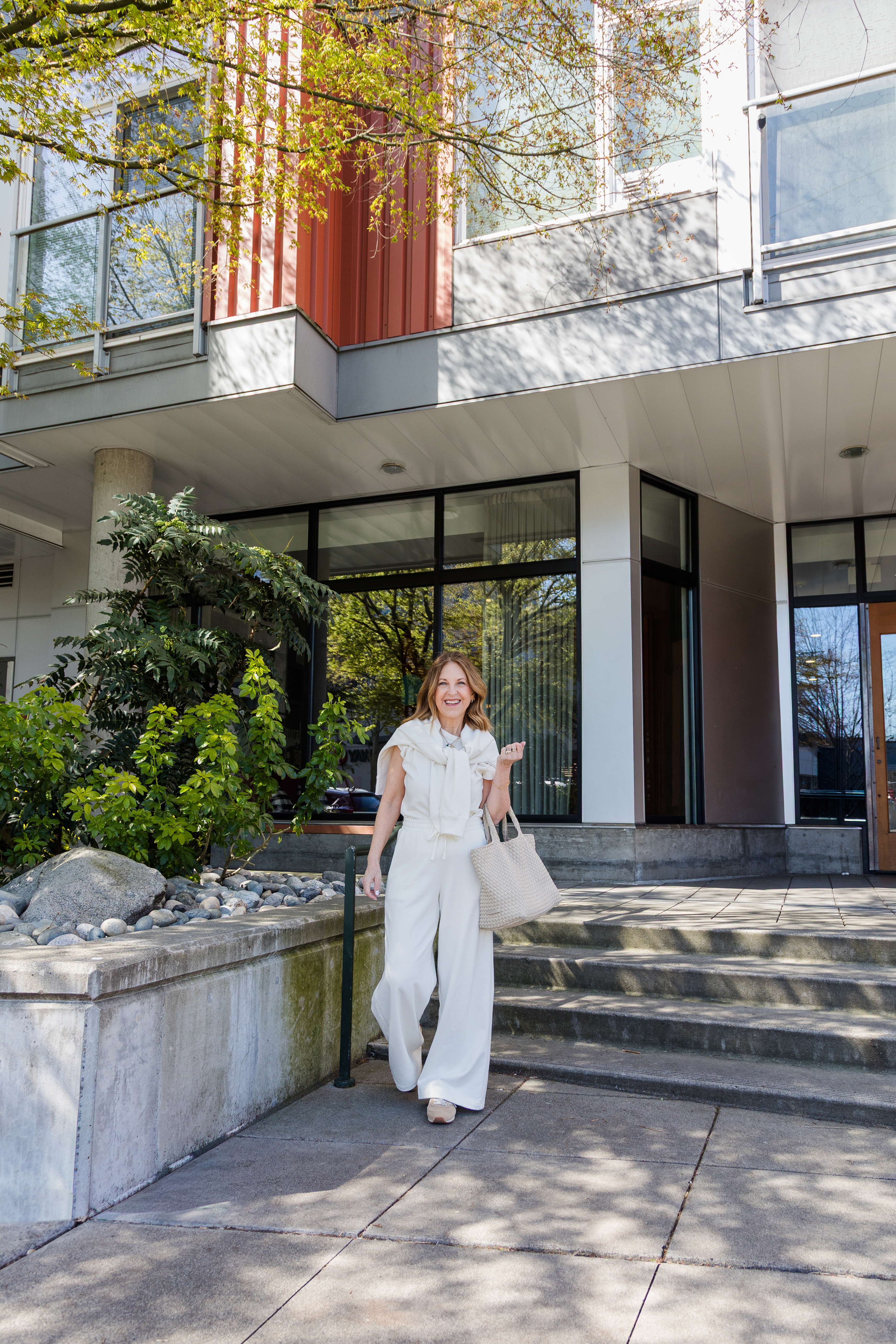 A former VIP Nordstrom stylist wearing an all white outfit with neutral-colored sneakers.