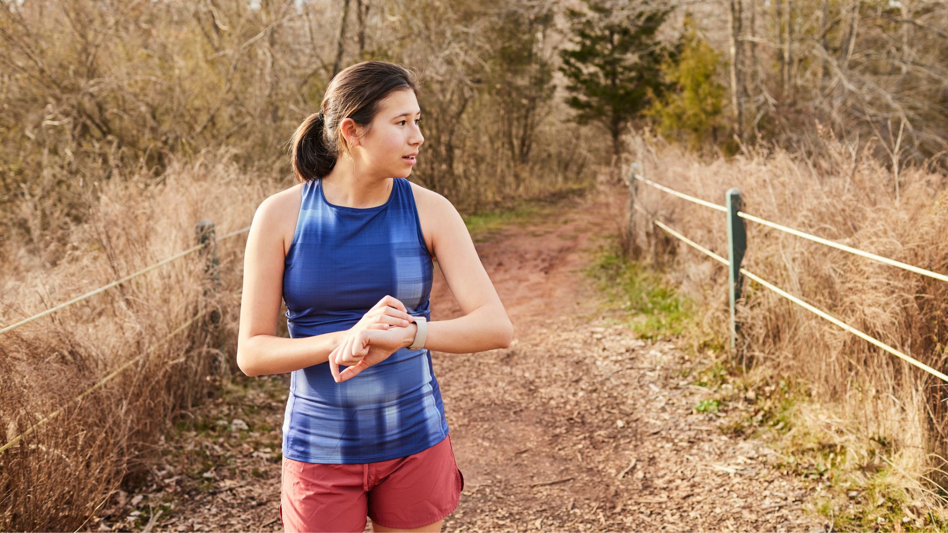 woman checks watch mid run outside