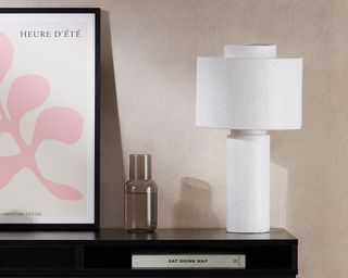 white table lamp on black console table with pink artwork