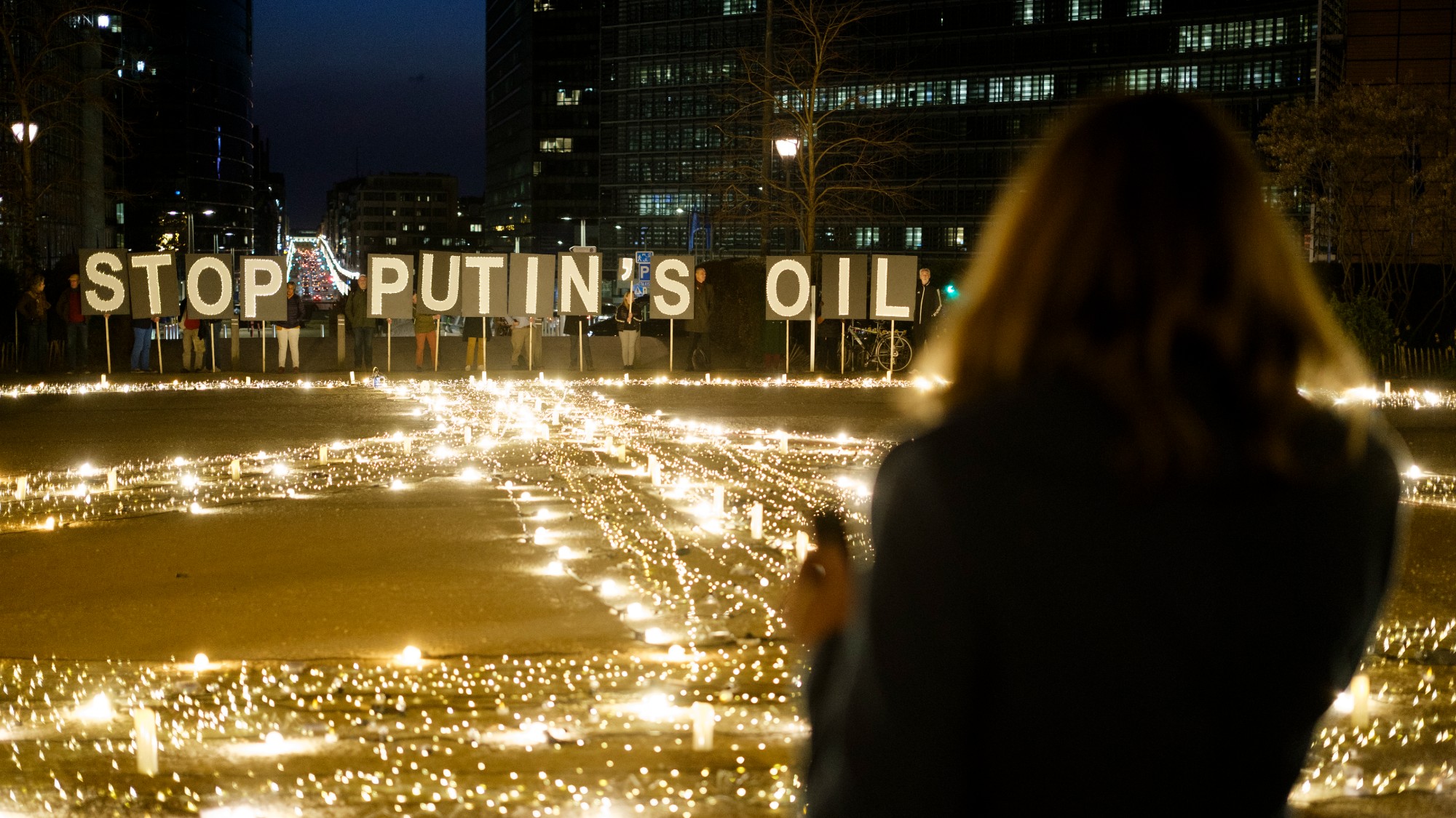 Avaaz activists and young Ukrainians demonstrate with a giant peace sign and 'Stop Putin's oil ' in front of EU institution buildings in Brussels