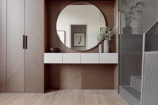 A wardrobe, vanity unit and circular mirror