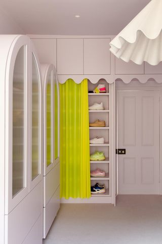Pink walk-in closet with neon yellow curtain to cover shoe storage