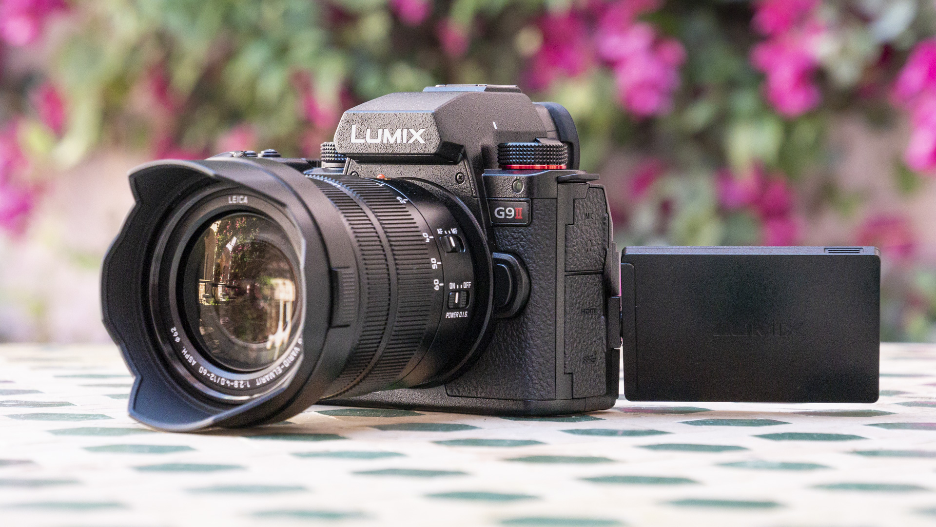 Panasonic Lumix G9 II camera on a patterned table with pink flower background