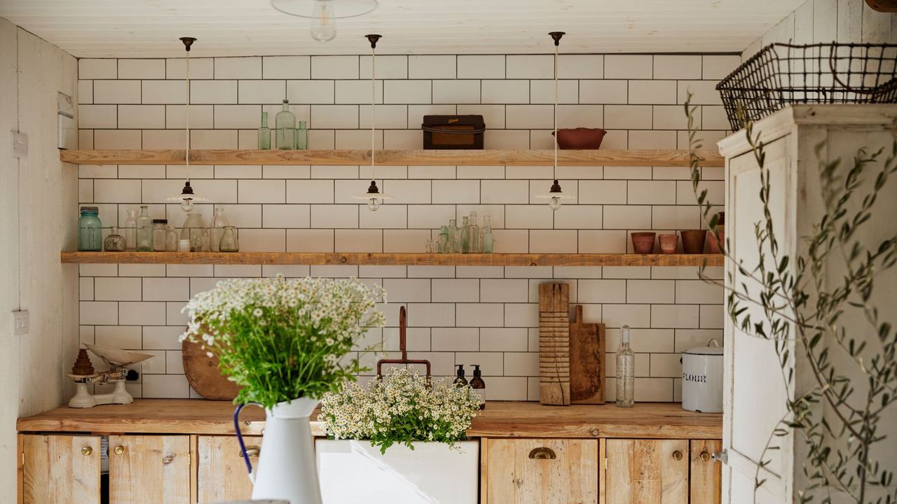 A laundry room or pantry with rustic wooden open shelves and a ceramic sink