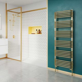 bathroom with teal walls and brass towel warmer and herringbone wall tiles