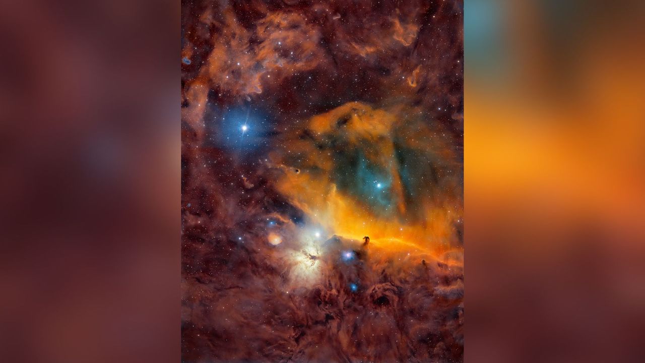 A nebula scene is shown with swirling clouds of brown, red and orange. Blue and white stars can be seen dotted throughout.